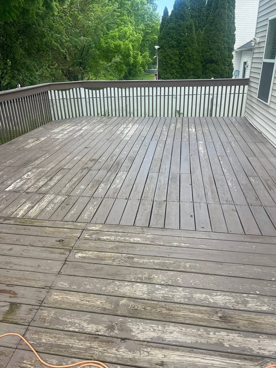 Weathered wooden deck with peeling stain, before restoration